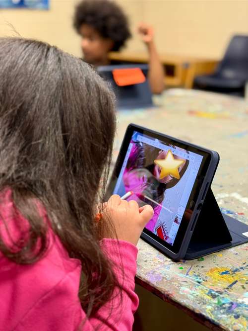Student has taken their picture on iPad and is now tracing her features to get started with her digital self portrait.