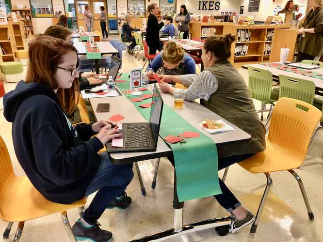 Educators in the media center at Indian Knoll ES working together on a collaborative project for professional learning. 