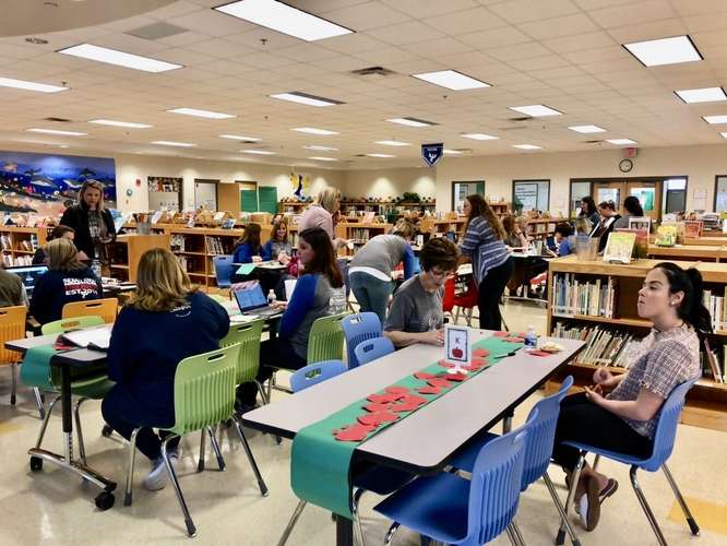 Educators in the media center of Indian Knoll ES exploring professional learning activities in a playground setting