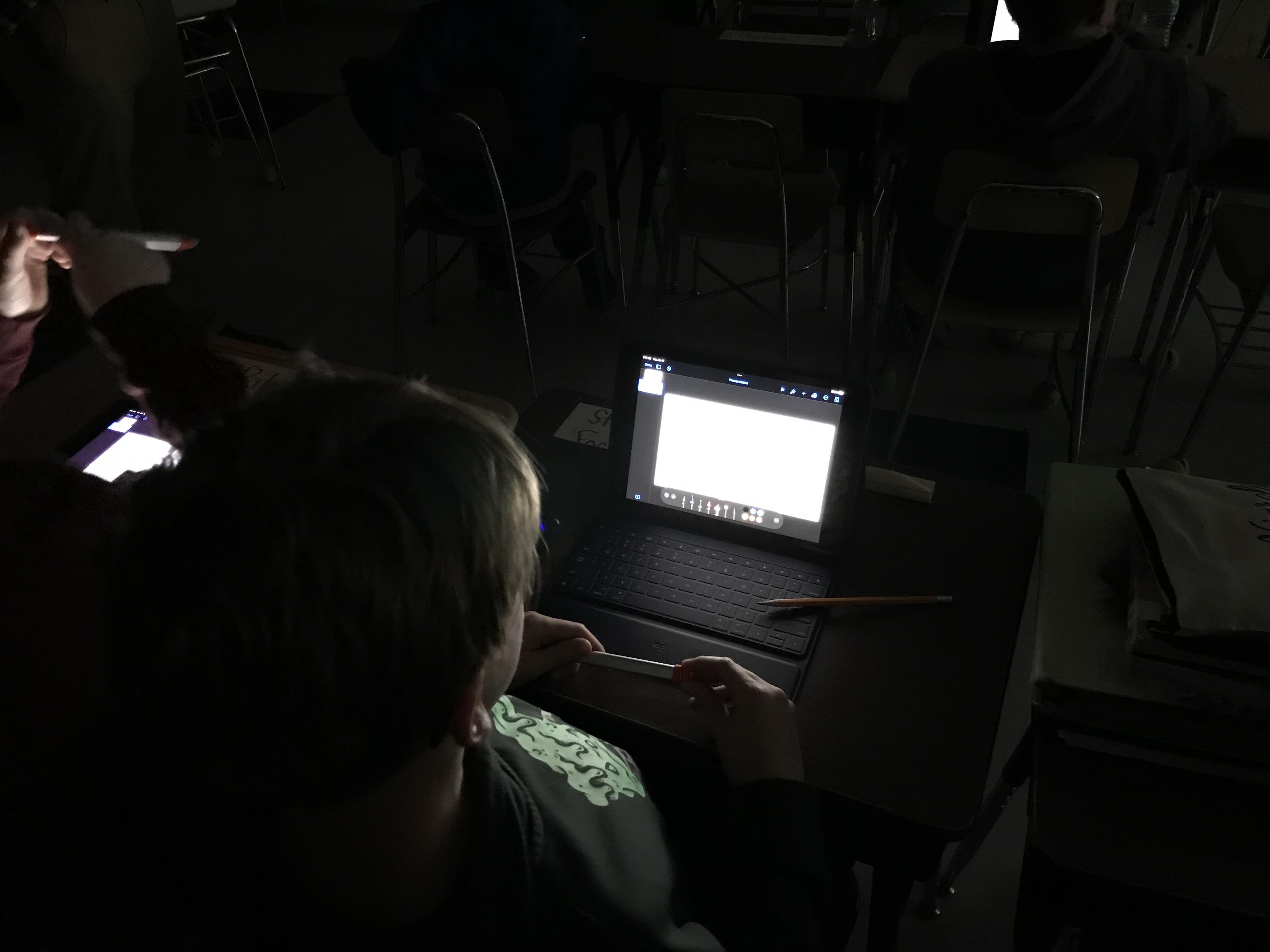 Student working in dark with iPad