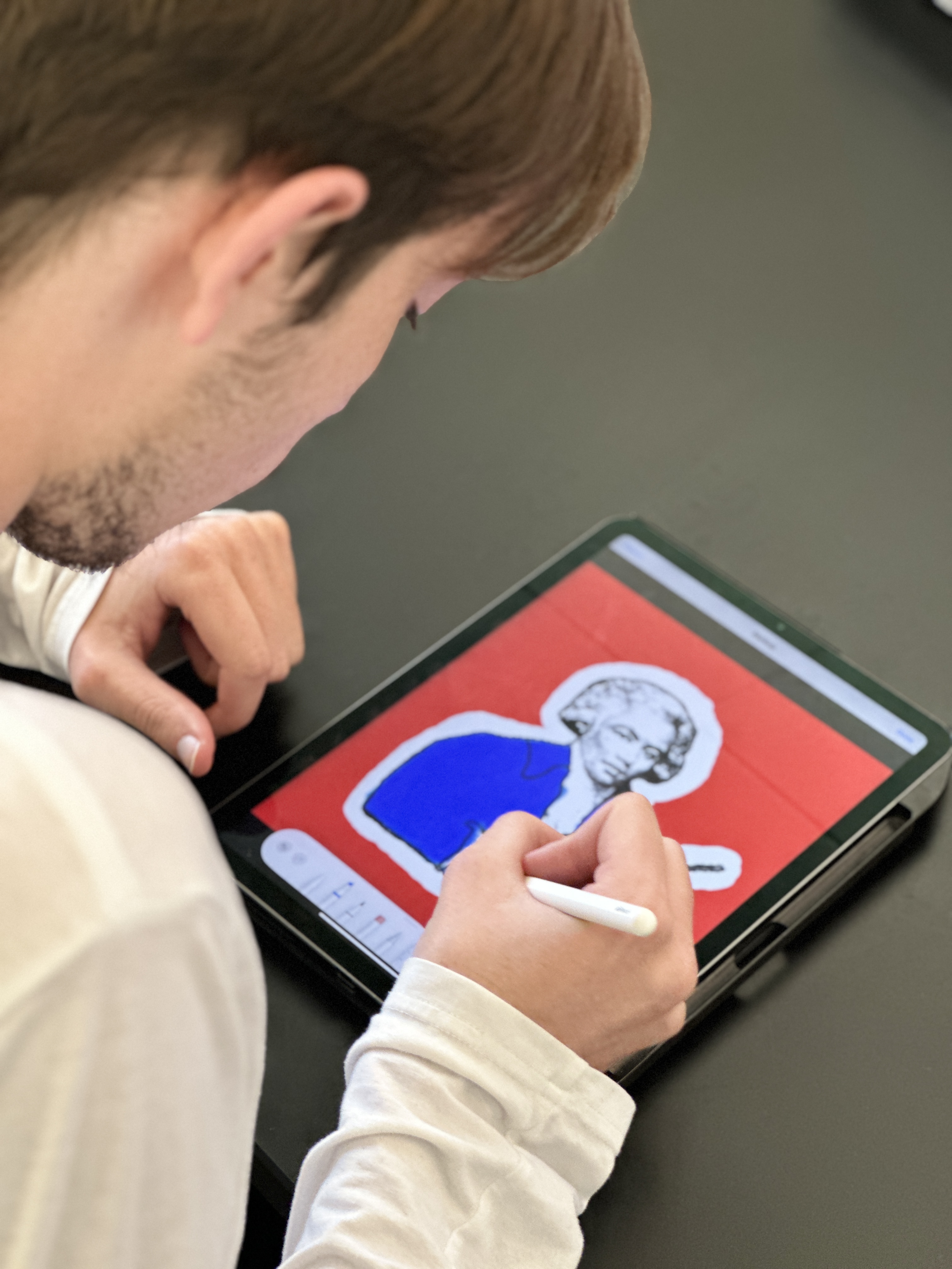 Student coloring an image of a composer on his iPad.