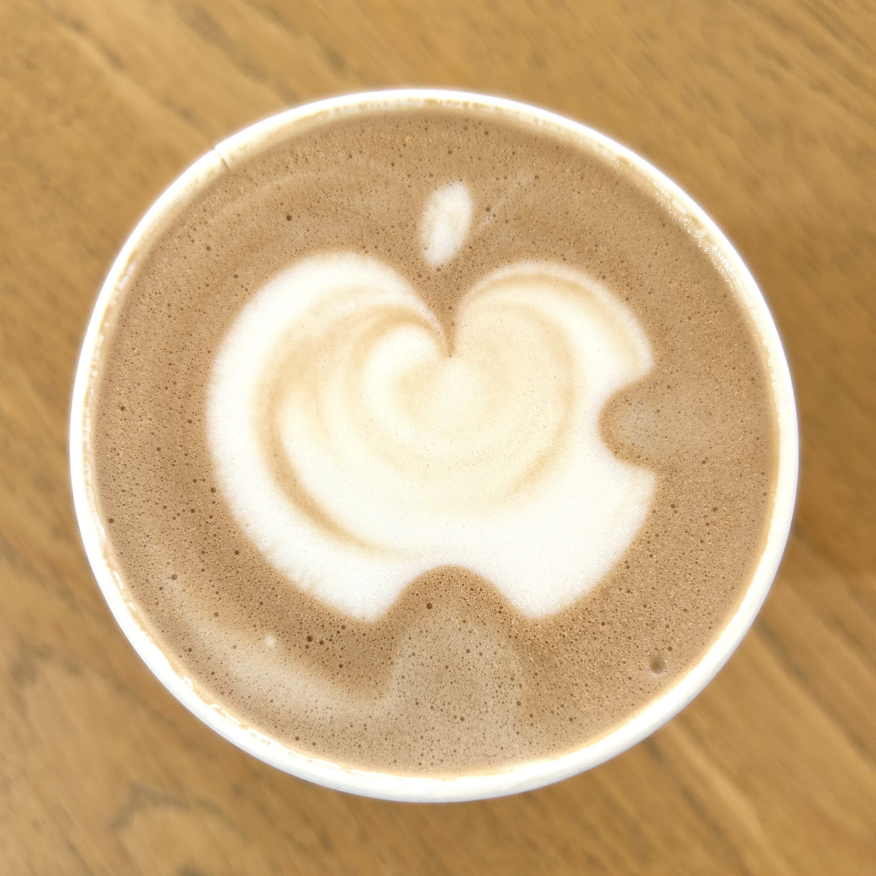View from overhead of a latte with the Apple logo created with foam art.