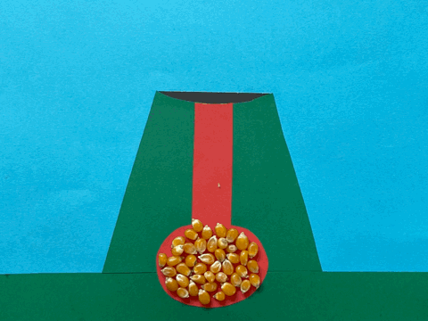 Animated GIF of a stop motion volcano made of coloured card with popcorn kernels and popcorn used to represent magma and lava