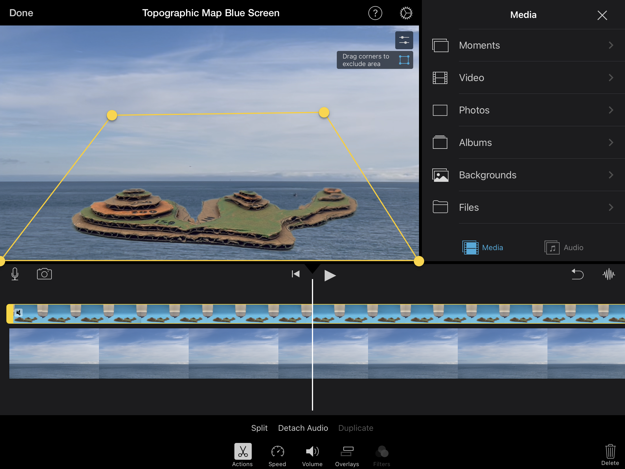 Screenshot from iMovie for iPad. A cardboard topographic map is surrounded by ocean using the Blue-Screen effect.